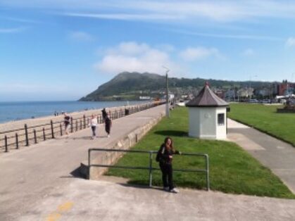 Bray é uma cidade costeira no norte do condado de Wicklow, na Irlanda. Depois de uns dias de chuva em Dublin, apareceu um lindo e sol, pegamos o trem e nos mandamos para cidade de Bray, pertinho de Dublin. Bray fica 40 minutos de trem do centro de Dublin, uma cidadezinha costeira, amigável e rodeada por muito verde. Bray é a primeira cidade e centro comercial e cultural do condado de Wicklow, o jardim da Irlanda.O ponto principal e cartão postal da cidade de Bray é o seu extenso calçadão gramado à beira da praia. De toda sua extensão, você pode contemplar a Bray Head, um monte de 241 metros, com uma cruz no topo, de onde se pode ter uma vista privilegiada de toda a cidade e do mar da Irlanda. Nao fomos ate o PICO…mas deu para comtemplar a cidade e o sol maravilhoso…