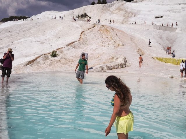 Após passarmos pela sauna marrons de Hireapolis, chegamos nos CASTELOS DE ALGODAO chamados por PAMUKKALE. Eu e Mami ficamos maravilhadas com tanta beleza e nunca poderiamos imaginar que estavamos ali.Montanha BRANQUINHA com piscinas em degraus, com água tépida e “sacadas” tão alvas que parecem chantilly, formadas pela paciente ação do tempo e do óxido de cálcio. Pelas cascatas desce uma água morninha e revigorante. Os romanos eram fissurados por Pamukkale, dizem que Cleopatra vinha de Roma apenas para banhar-se nas aguas, pois acreditava que eram beneficas e aumentava sua beleza. Ate hoje existe a famosa piscina escolhida por cleopatra, custa 10 euros banhar-se…hehehehhe. Retornarei para pamukkale assim que minha beleza decair….heheheheh